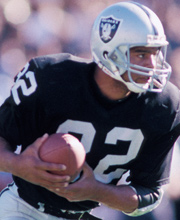 Pro Football Hall of Famer Marcus Allen wearing number 32 for the LA Raiders rushing the ball