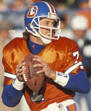 Pro Football Hall of Famer John Elway wearing number 7 for the Denver Broncos dropping back for a pass