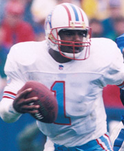 Pro Football Hall of Famer Warren Moon wearing number 1 for the Houston Oilers dropping back for a pass